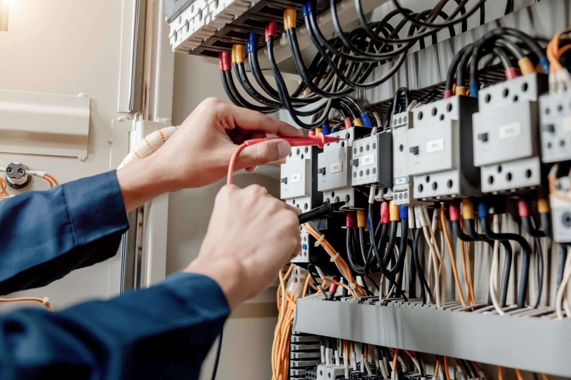 Electrician engineer uses a multimeter to test the electrical installation and power line current.